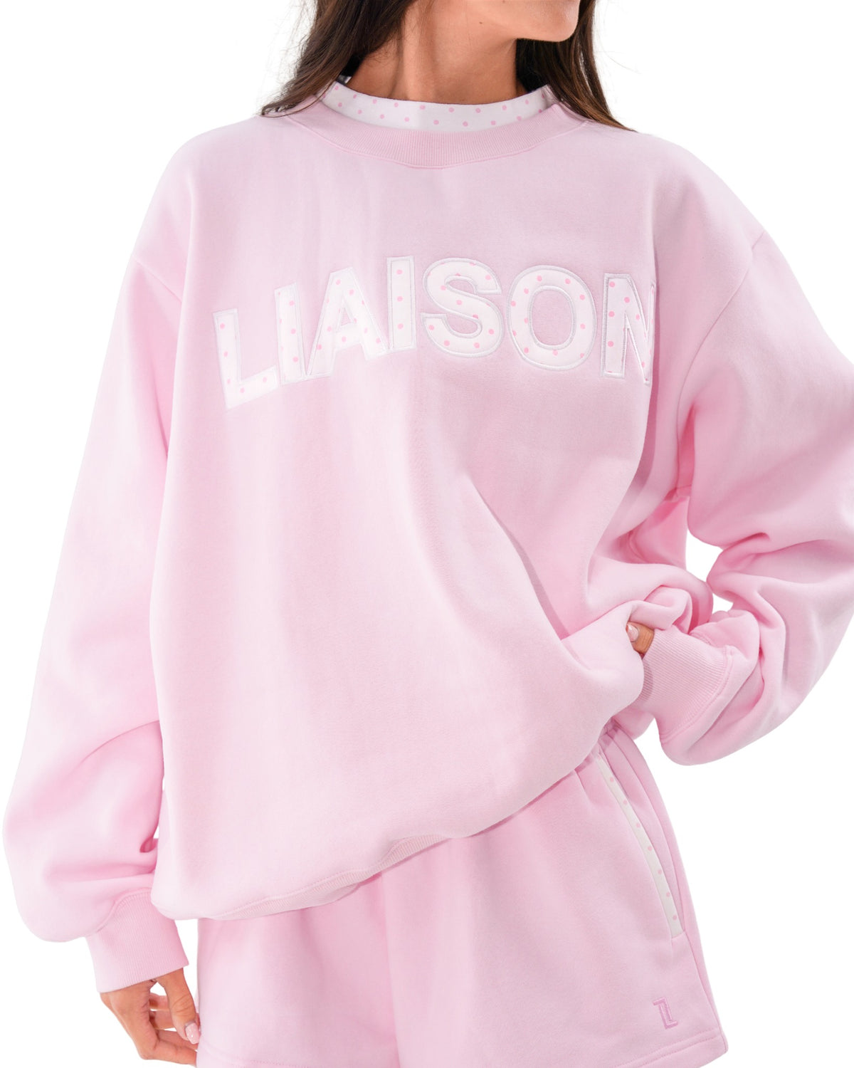 front view of model wearing the layered mockneck in soft pink and white polka dots